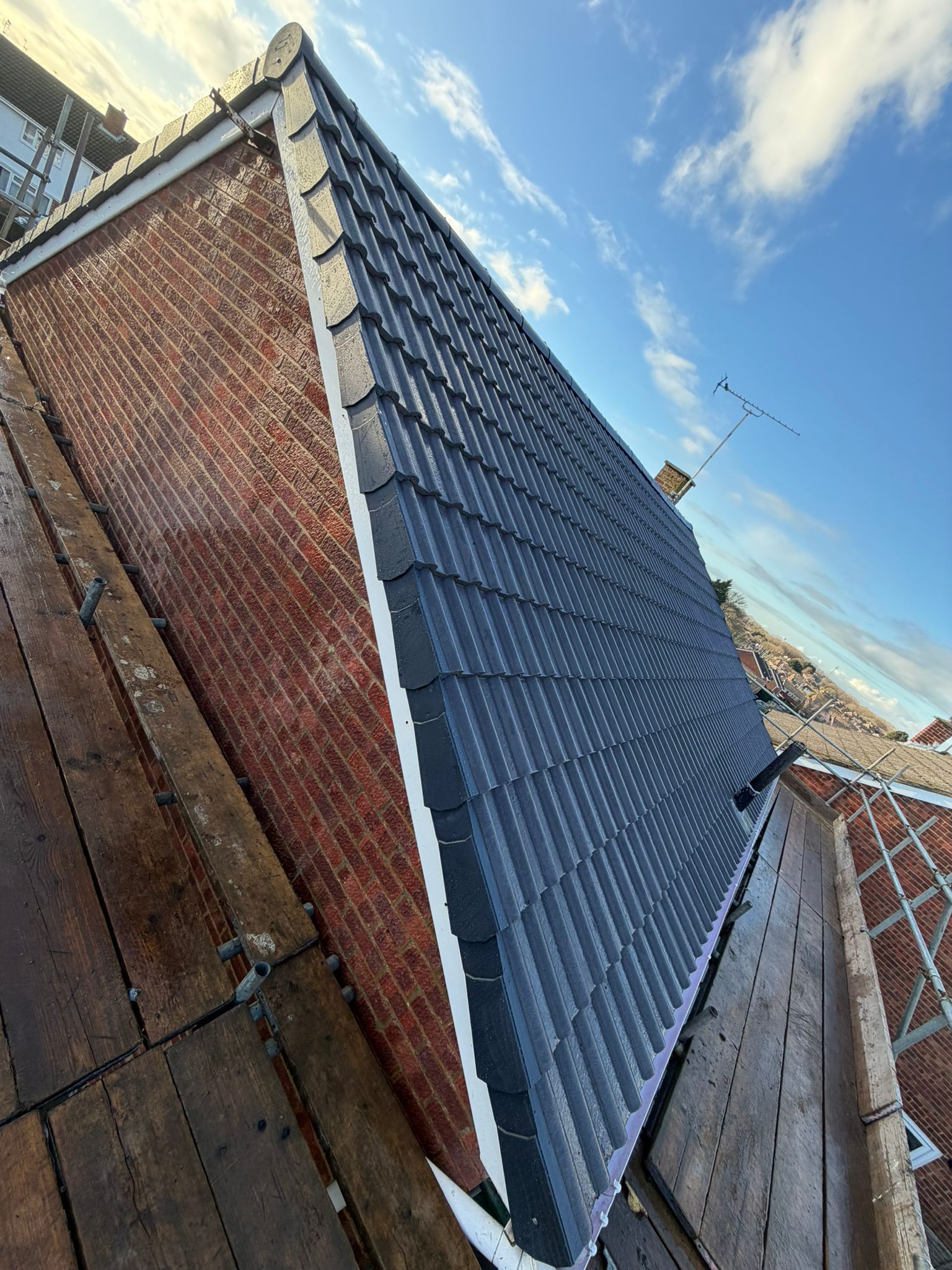 New roof installation with tiles on a brick house